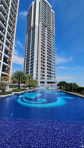 a large swimming pool in front of a tall building at Artisan Ratchada Spacious 2BR Condos in Bangkok