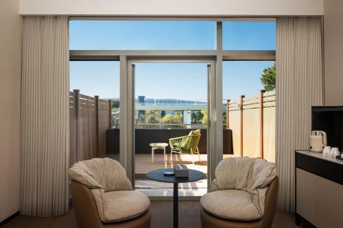 a living room with two chairs and a table and a balcony at Mlily Hotel in Shanghai