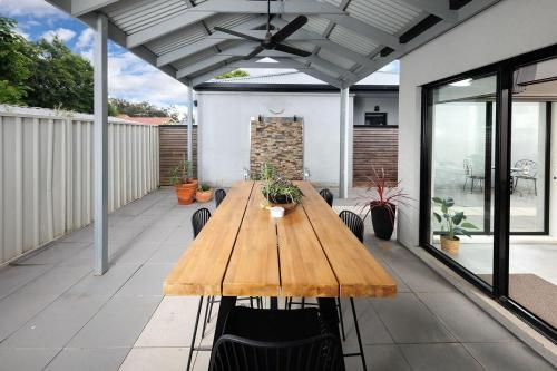 a wooden table and chairs on a patio at Little Palace on Buckingham in Lavington