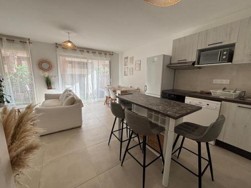 une cuisine et un salon avec une table et des chaises dans l'établissement Cozy cocoon 2-bedroom apartment, à Agde