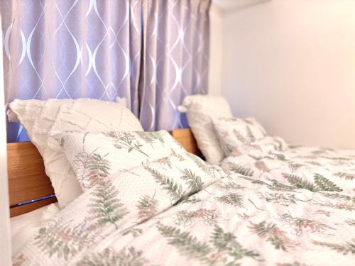 a bed with a comforter and pillows on it at 29Nooks ナチュラル in Nagoya