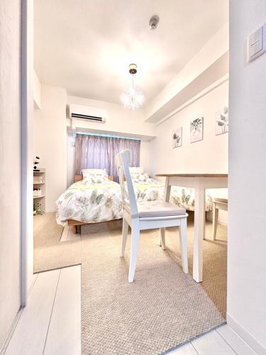 a white bedroom with a bed and a chair at 29Nooks ナチュラル in Nagoya
