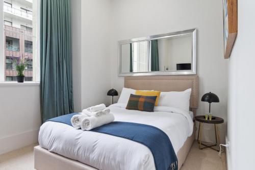 a bedroom with a large bed with towels on it at slick city apartment in Auckland