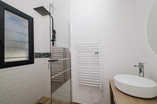 une salle de bain avec un lavabo et une douche en verre dans l'établissement VILLA PRESTIGE Les Grenadiers, à Cabestany