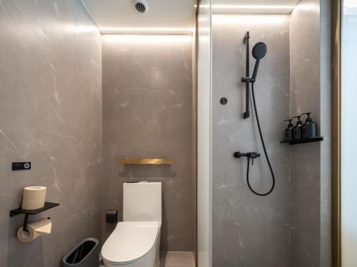 a small bathroom with a toilet and a shower at Atour X Hotel Zhengzhou Provincial Museum Beach Temple Metro Station in Zhengzhou