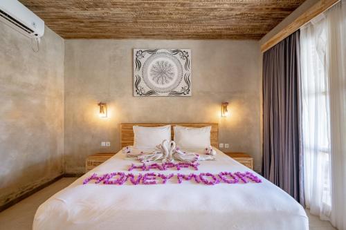 a bedroom with a large bed with pink flowers on it at Golden Garuda Cottages at Diamond Beach Hills in Nusa Penida
