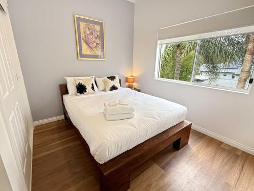 a bedroom with a large white bed with a window at Buffalo River Retreat - 5 Bedroom in Myrtleford