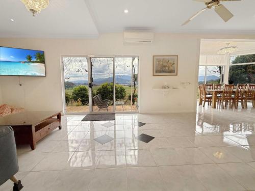 a living room with a ceiling fan and a table at Buffalo River Retreat - 6 Bedroom in Myrtleford