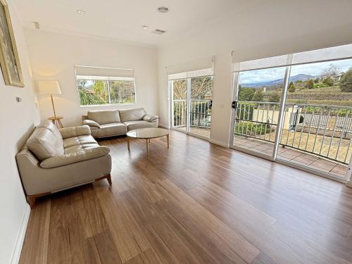 a living room with a couch and a table at Buffalo River Retreat - 6 Bedroom in Myrtleford