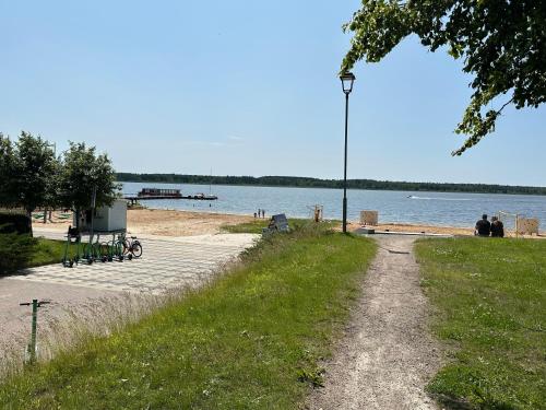 a path next to a beach with a street light at Sofi Apartment in Võru