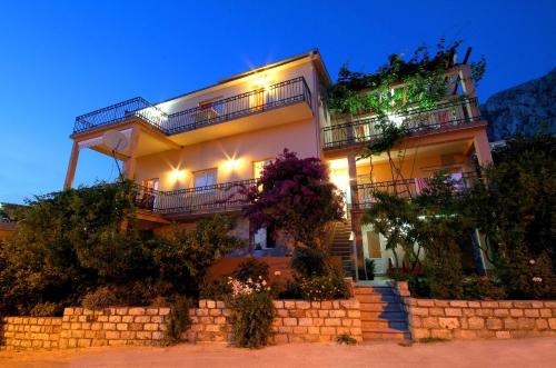 a large house with lights on it at night at Apartments Grand in Sveti Stefan