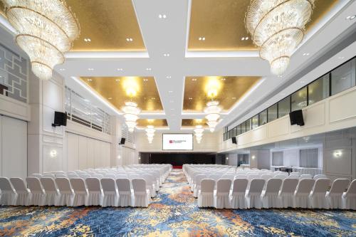 a large room with white chairs and a stage at Hilton Garden Inn Shanghai Jiading in Shanghai
