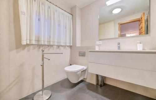 a white bathroom with a toilet and a sink at Experience the running of the bulls from your balcony in Pamplona