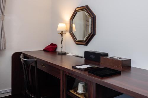 a desk with a mirror and a lamp on it at Matsumoto Hotel Kagetsu in Matsumoto