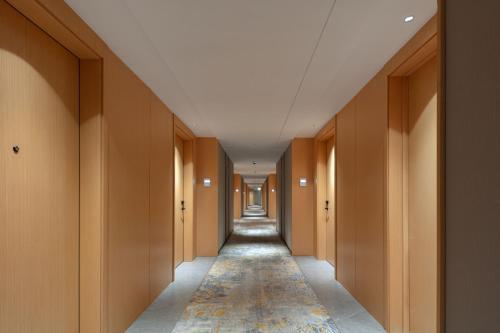 a long corridor with wooden walls and a long hallway with a long aisle at Hilton Garden Inn Shanghai Jiading in Shanghai