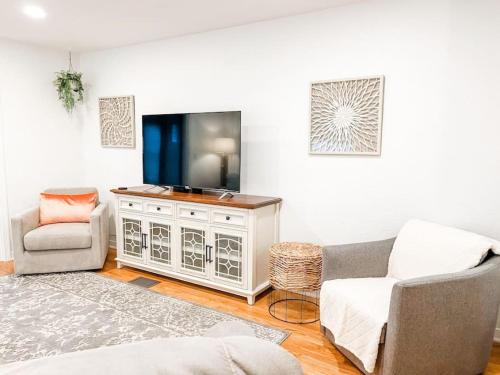 Una sala de estar con televisión, sofá y sillas. en Changes In Latitude Pet Friendly Retreat, en Daytona Beach