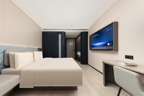 a hotel room with a bed and a tv at Atour Hotel Shanghai People Square Beijing East Road in Shanghai