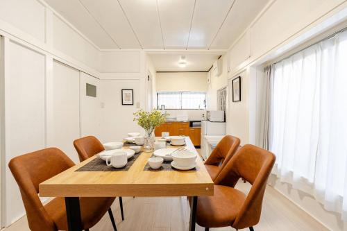 ein Esszimmer mit einem Holztisch und Stühlen in der Unterkunft Higashi tateishi Kodate HTI1 in Tokio