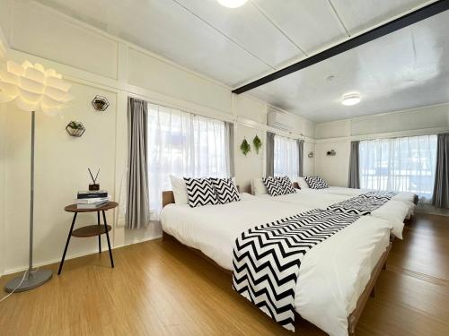 ein großes Schlafzimmer mit 2 Betten und einem Tisch in der Unterkunft Higashi tateishi Kodate HTI1 in Tokio