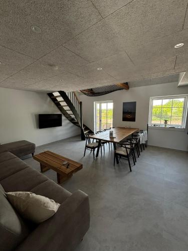 a large living room with a table and chairs at inNature Haurholm Apartments in Lønstrup