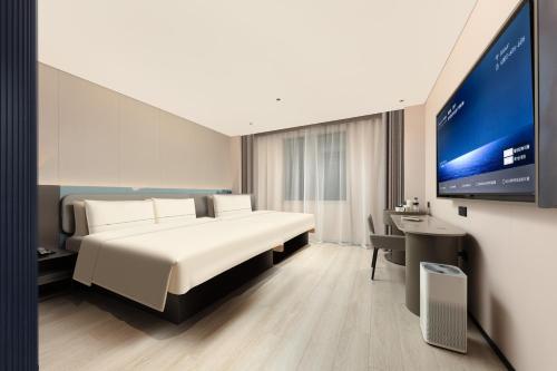 a hotel room with a bed and a flat screen tv at Atour Hotel Shanghai People Square Beijing East Road in Shanghai