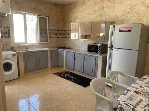 una cocina con refrigerador y lavadora y secadora en Villa Djerba Midoun, en Al Maqārisah