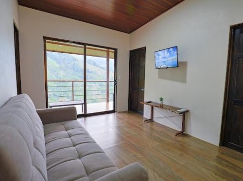 a living room with a couch and a television in it at VILLA SANTA LUCÍA in front of the waterfall with a mountain view in Ceibo