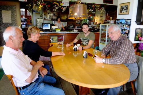un grupo de personas sentadas alrededor de una mesa de madera en Hotel Löwen, en Kirchzarten