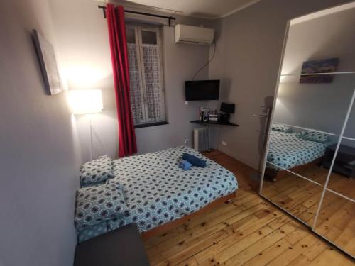 une petite chambre avec un lit et un miroir dans l'établissement Studio Calme avec Jardin, Tram T6 et Métro D, Lyon 8, à Lyon