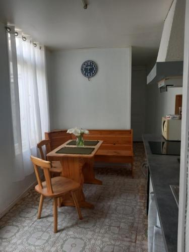 a dining room with a table and a bench at La Maison de Didier in Guînes