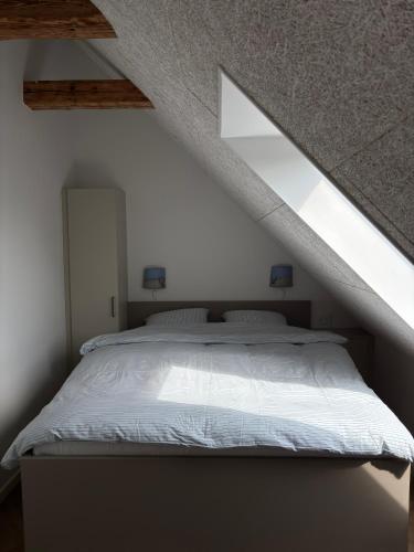 a bedroom with a large bed in a attic at inNature Haurholm Apartments in Lønstrup