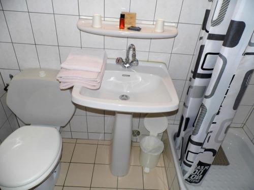 a white bathroom with a toilet and a sink at Résidence des Touristes in Pierrefitte-Nestalas