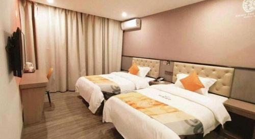 a hotel room with two beds and a television at Shell Hotel Shanghai Jinshan Wanda Plaza in Nanhui