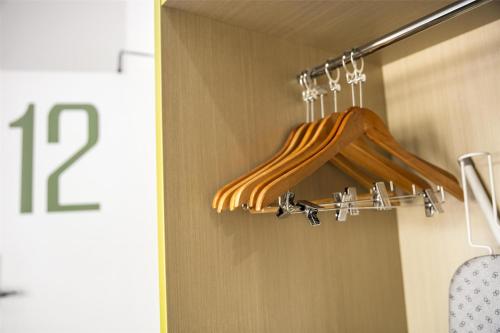 a closet with a wooden hanger in a room at Nightcap at Caringbah Hotel in Caringbah