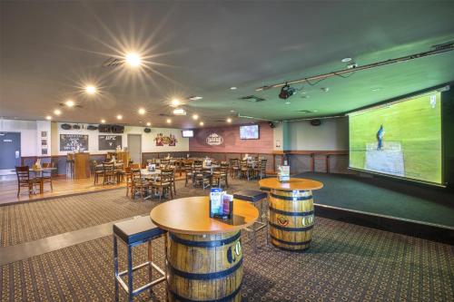 a room with tables and chairs and a large screen at Nightcap at Springwood Hotel in Springwood