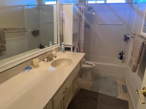 a bathroom with a sink and a toilet and a mirror at STR25-15 Master Bedroom Marina in Marina
