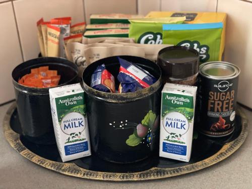 a plate with three cans of milk and some food at Florence Lodge in Berridale