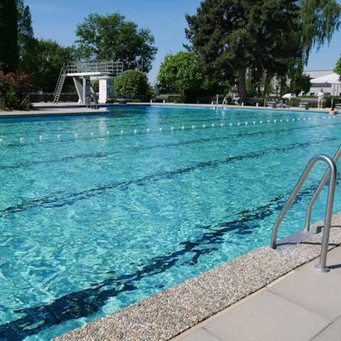 a large swimming pool with blue water at Ferienwohnung Sonnenblick in Hilzingen