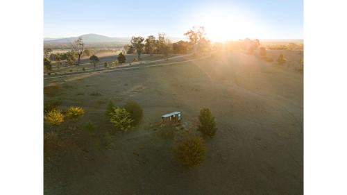 a bench sitting in the middle of a field at The High Country Views Escape by Tiny Away in Table Top