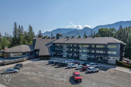 a large building with cars parked in a parking lot at Griz Inn by StayIn in Fernie