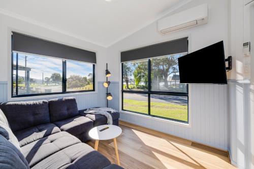 a living room with a couch and a flat screen tv at South Coast Retreat in Greenwell Point