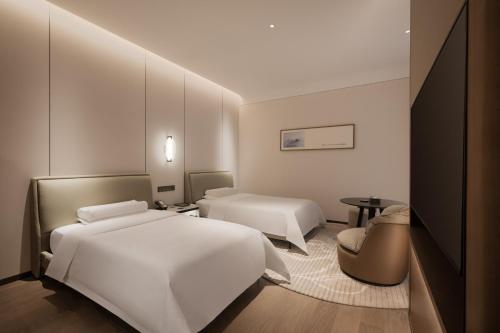 a hotel room with two beds and a table at Mlily Hotel in Shanghai