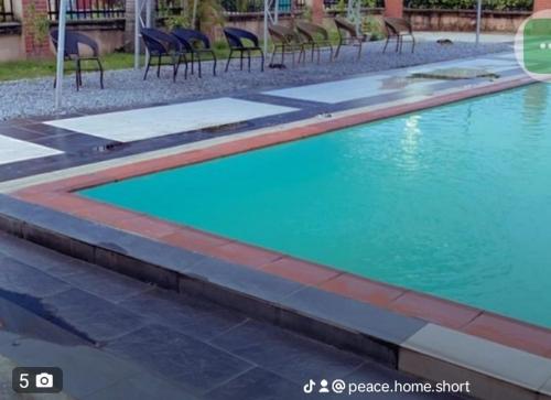 an empty swimming pool with chairs in a building at Peace Home in Lekki
