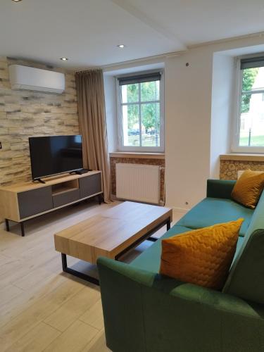 a living room with a couch and a coffee table at Stara Kamienica pod Białym Łabędziem in Srebrna Góra