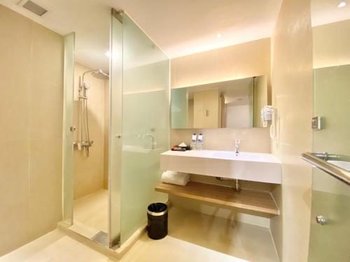 a bathroom with a sink and a shower at Grand Zuri Malioboro in Yogyakarta