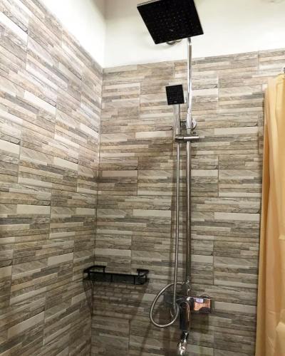 a bathroom with a shower with a stone wall at Mamat Top Homestay in Huu