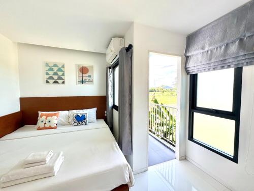 a bedroom with a bed and a window at Udomsap place in Na Jomtien