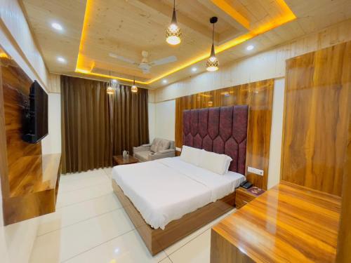 ダルハウジにあるHotel Dalhousie Hillsのベッド、ソファ、テレビのある寝室