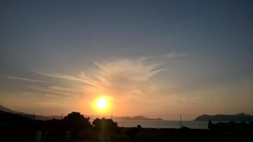 a sunset over the water with the sun in the sky at Vigles in Adamas
