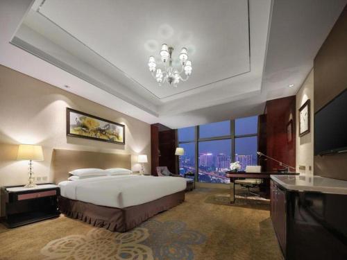 a bedroom with a large bed and a large window at Dongwu New Century Grand Hotel Huzhou in Huzhou